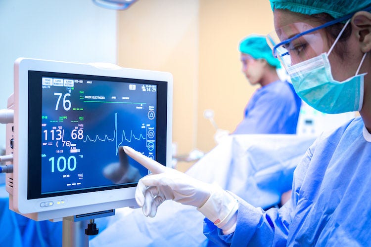 Female surgeon using monitor in operating room.