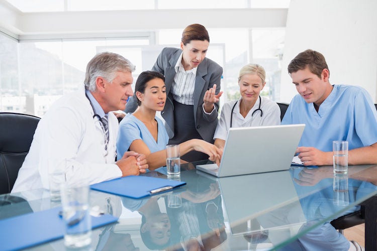 Team of doctors and businesswoman having a meeting in medical office