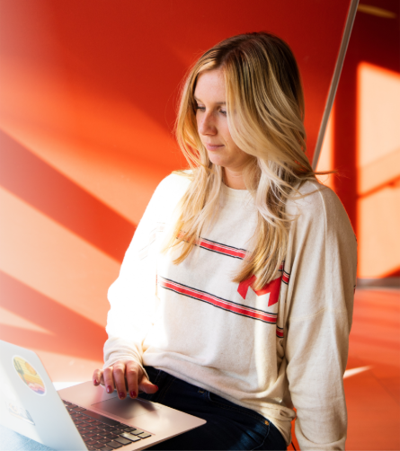 Student working on their laptop in a Maryville sweater