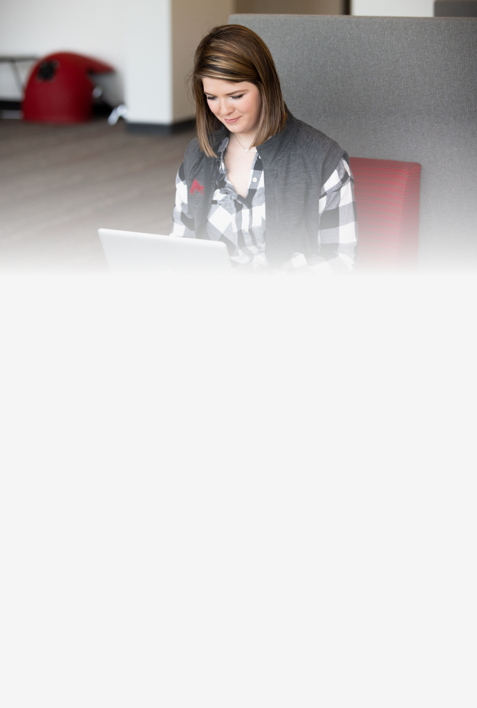 Student sitting indoors on her computer