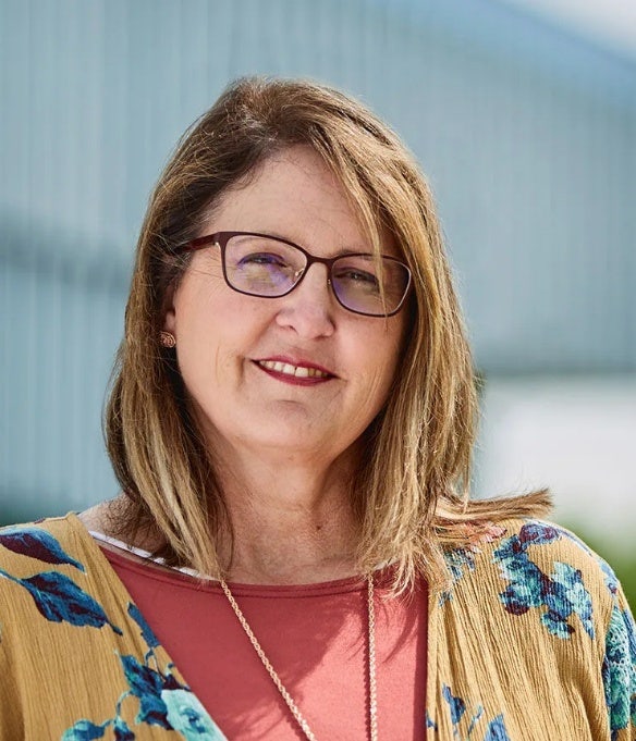 Brenda Dinges smiling and standing in front of Maryville University