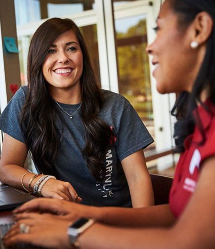 Student support specialist helping online student in café
